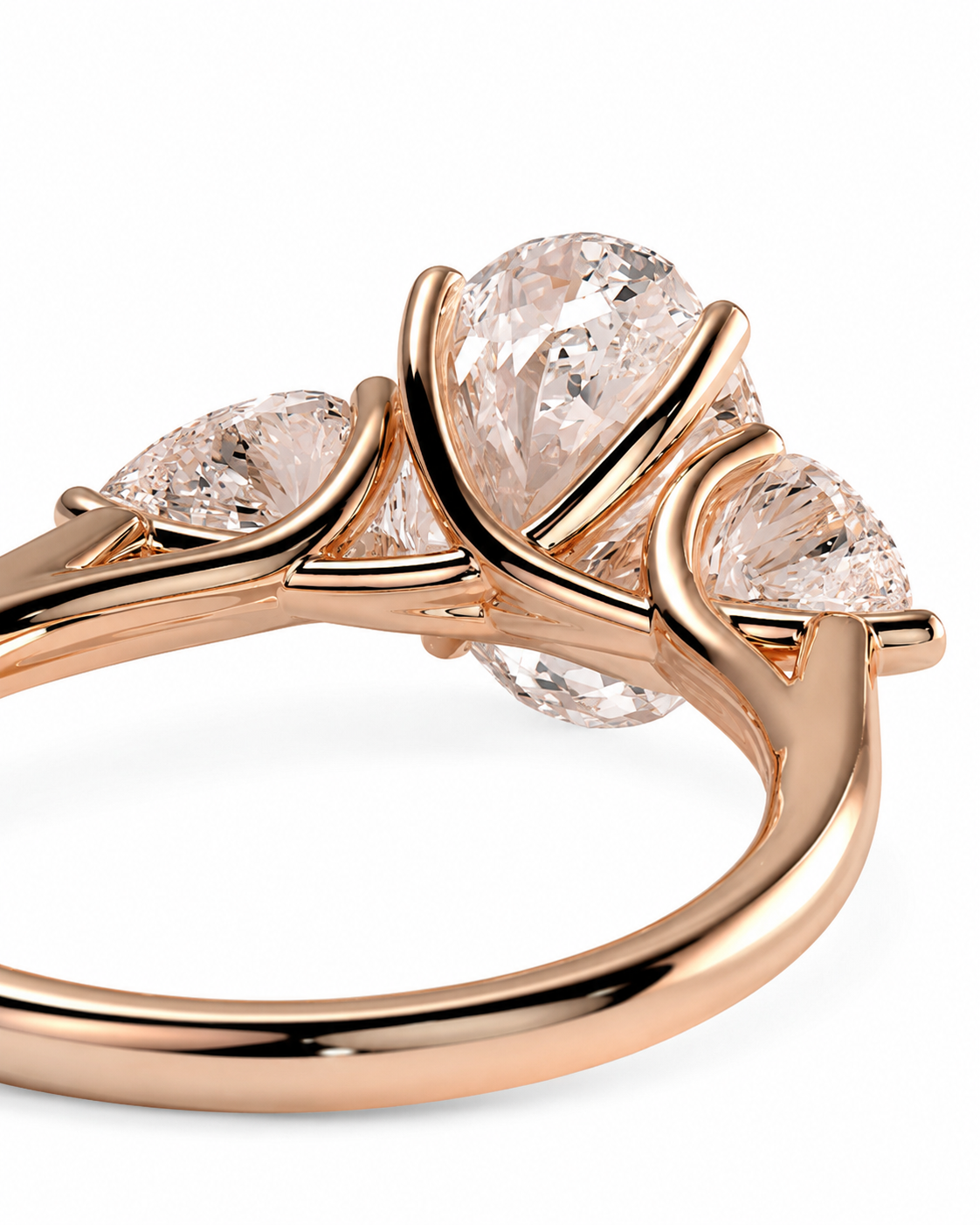 color_10K_RG, color_14K_RG &&
Rose gold ring with three pear-cut clear gemstones in a curved, intertwined setting, shown on a clean white background.