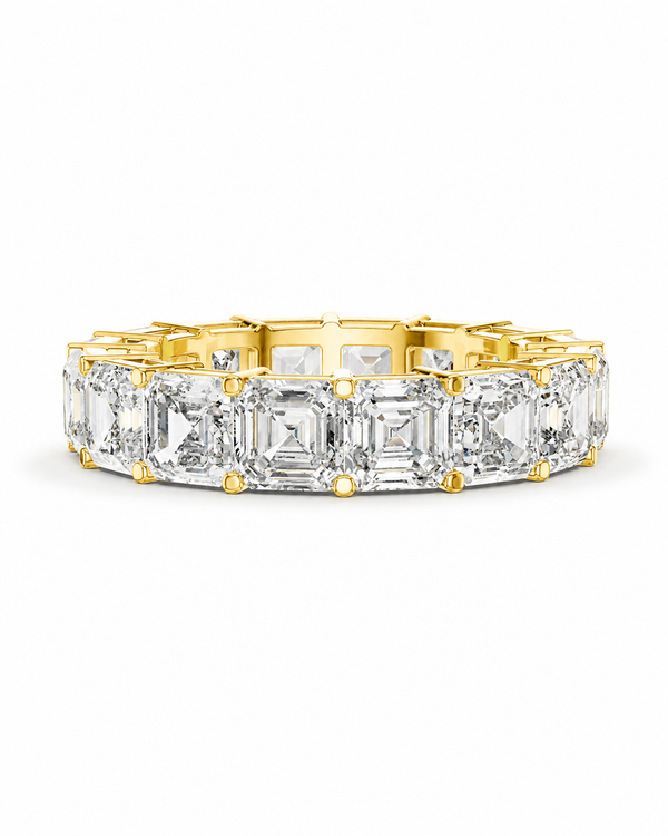 color_10K_YG, color_14K_YG &&	
A yellow gold eternity band ring featuring a row of large, clear emerald-cut diamonds set in a polished gold-plated band, shown against a plain white background.
