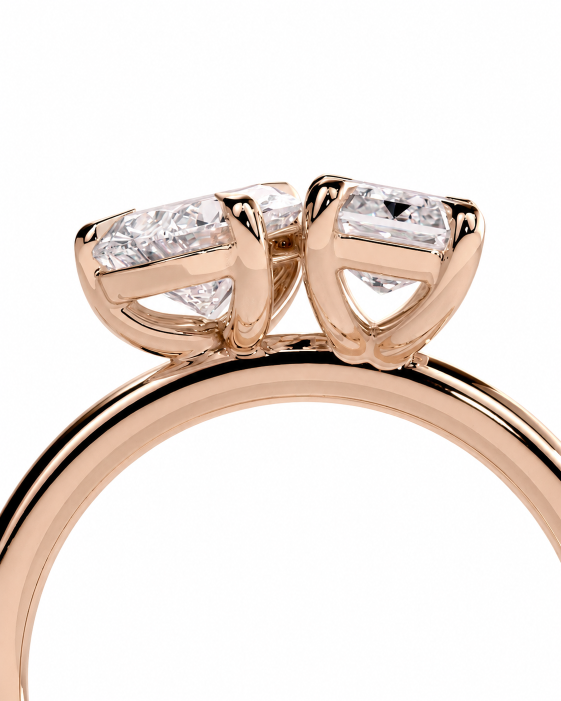 color_10K_RG, color_14K_RG &&
A close-up of a rose gold ring featuring two marquise-cut clear gemstones in a split setting, shown against a plain white background.