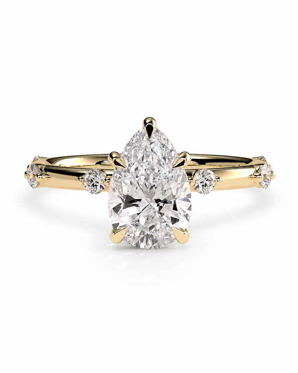color_10K_YG, color_14K_YG &&
A yellow gold ring featuring a large pear-cut center diamond and smaller round diamonds on the shoulders, set against a clean white background.