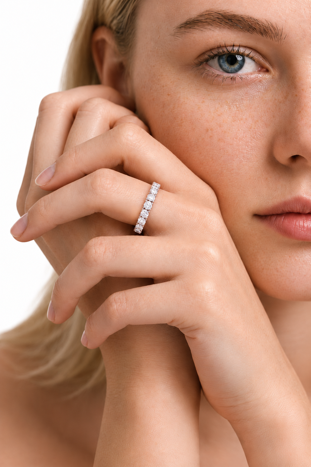 color_925_SIL,color_935_ARG,color_10K_WG, color_14K_WG &&	
A close-up lifestyle shot of a woman wearing a sparkling diamond eternity ring on her finger, with her hand resting against her cheek against a clean white background.