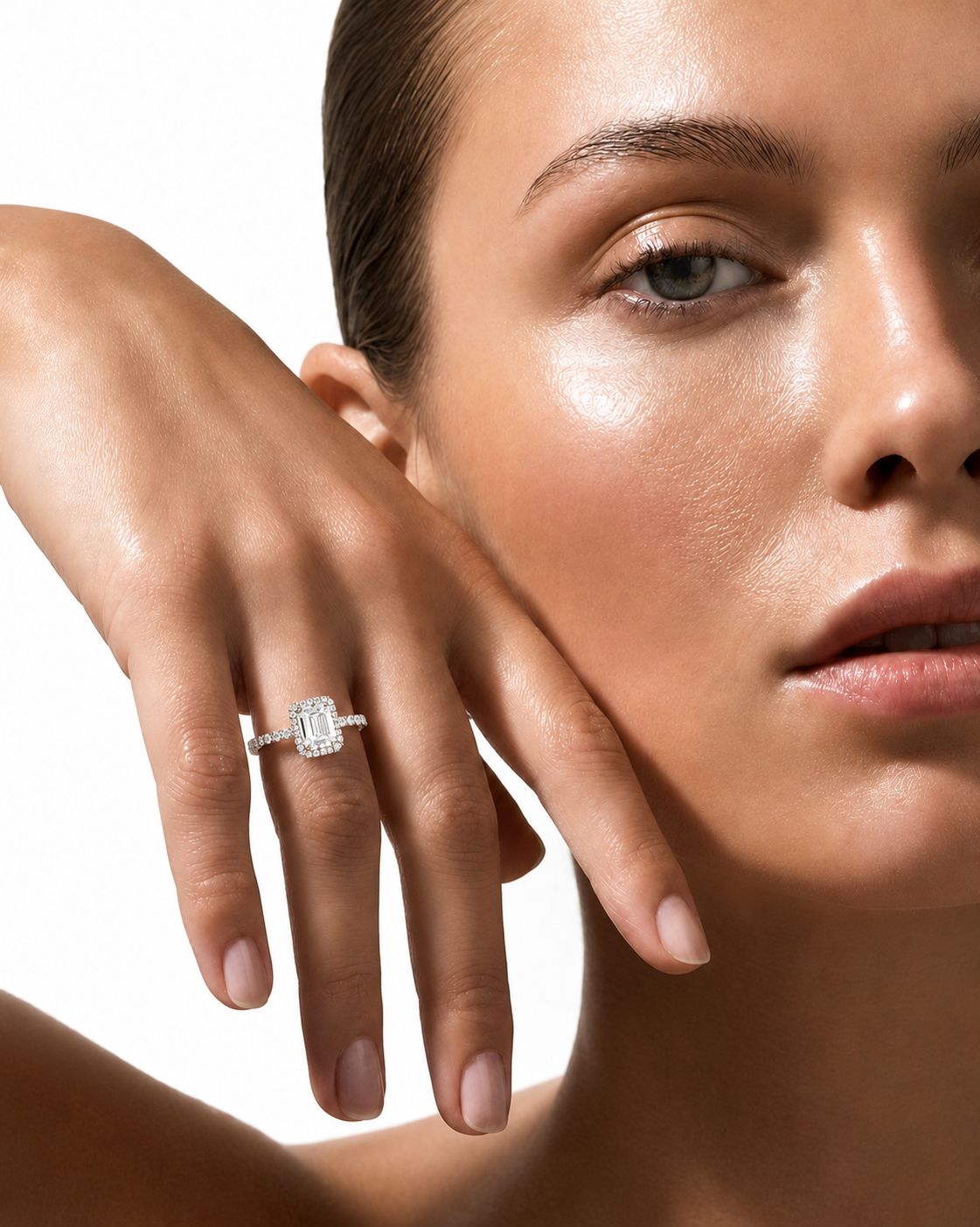 color_925_SIL,color_935_ARG,color_10K_WG, color_14K_WG &&A close-up lifestyle shot of a model wearing a diamond engagement ring on her finger, with her face and hand prominently framed against a clean white background.