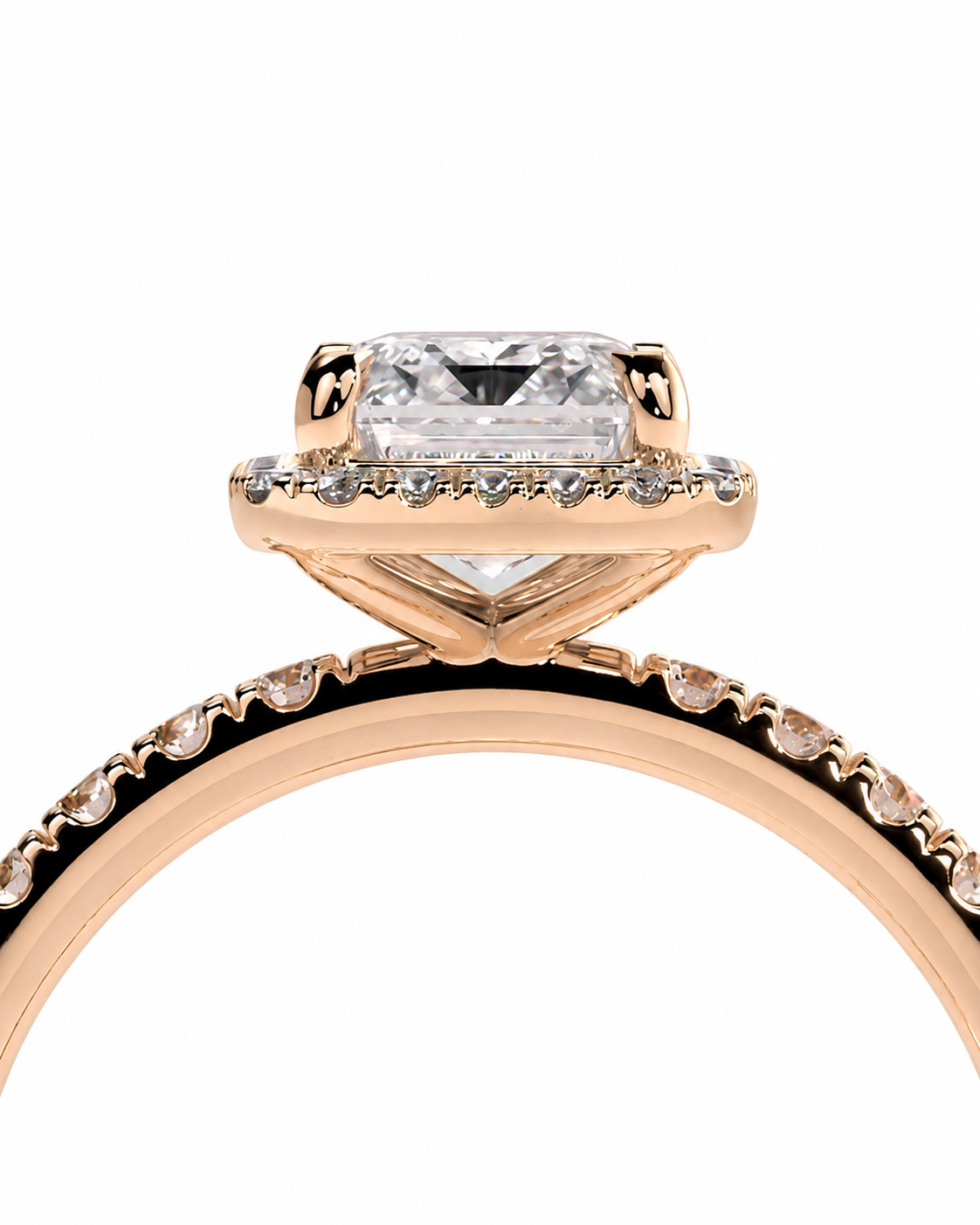 color_10K_RG, color_14K_RG &&A close-up of a rose gold engagement ring featuring a rectangular clear gemstone in a halo setting, with a pave band accented by small round stones, shown on a plain white background.