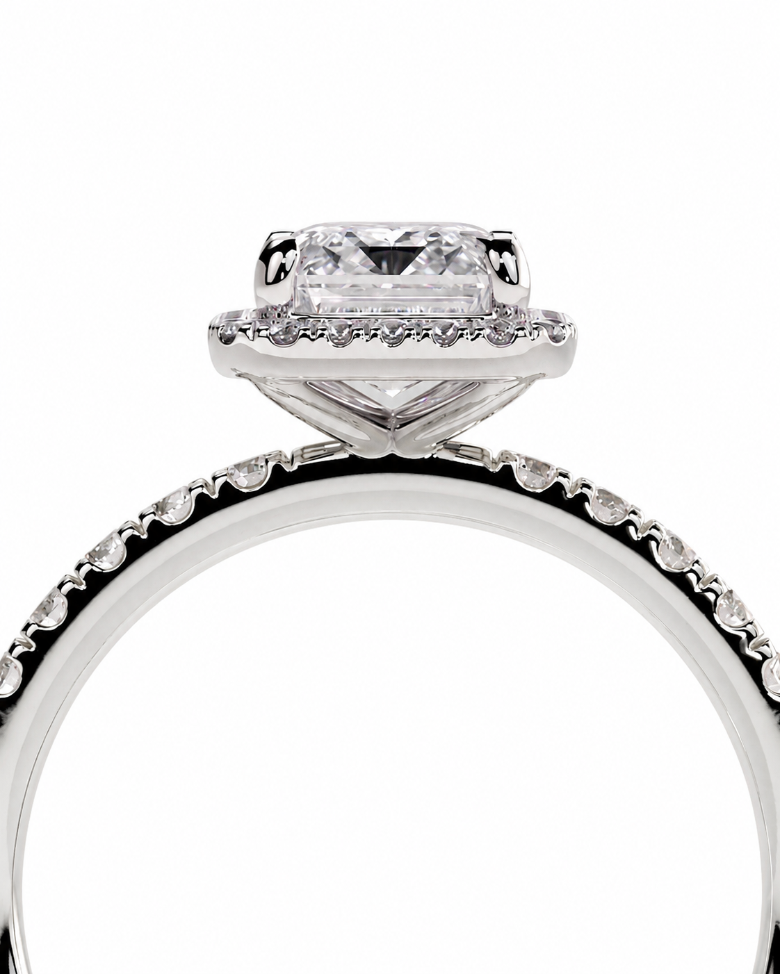 color_925_SIL,color_935_ARG,color_10K_WG, color_14K_WG &&A close-up studio shot of a silver-toned engagement ring with a rectangular clear center stone and a halo of small clear stones, set against a plain white background.