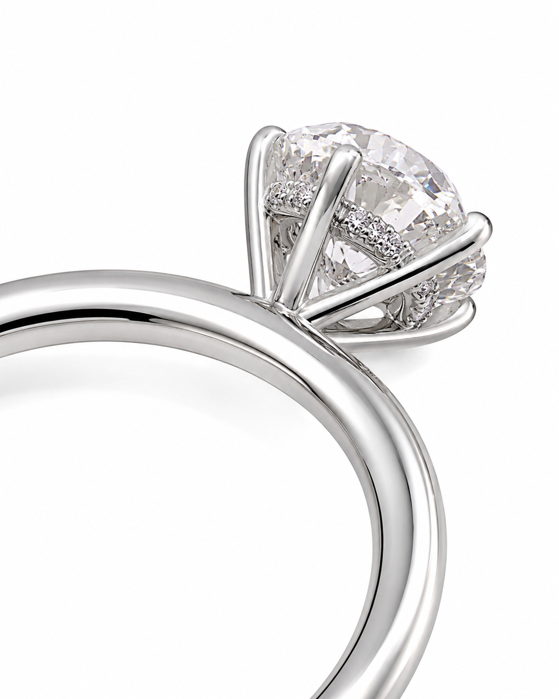 color_925_SIL,color_935_ARG,color_10K_WG, color_14K_WG &&A close-up studio shot of a silver-toned ring with a large round clear gemstone in a prong setting, with small pave accents on the band, on a white background.