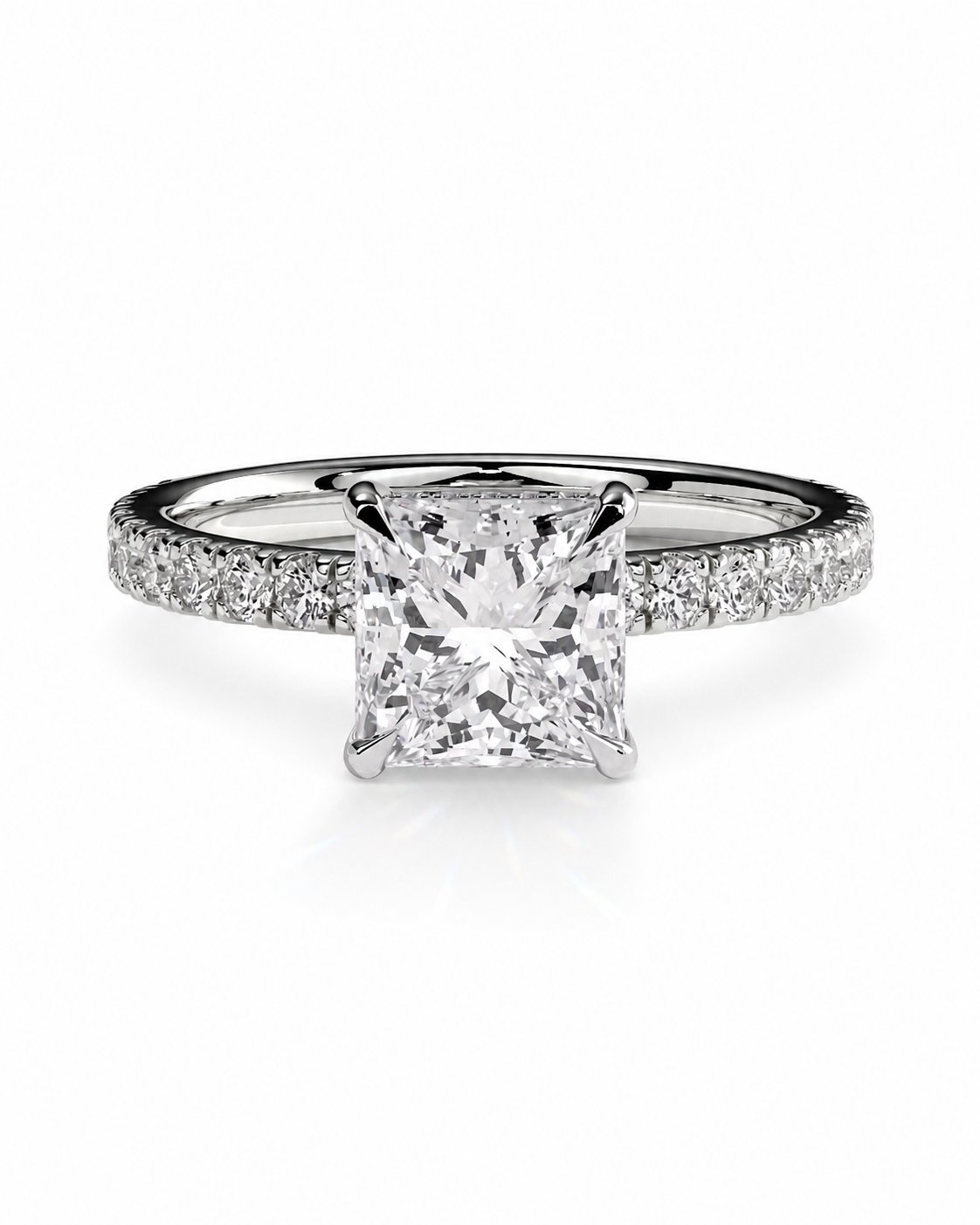 color_925_SIL,color_935_ARG,color_10K_WG, color_14K_WG &&A radiant cut diamond solitaire engagement ring with a pave-set diamond band in a silver-colored metal, shown on a clean white background.
