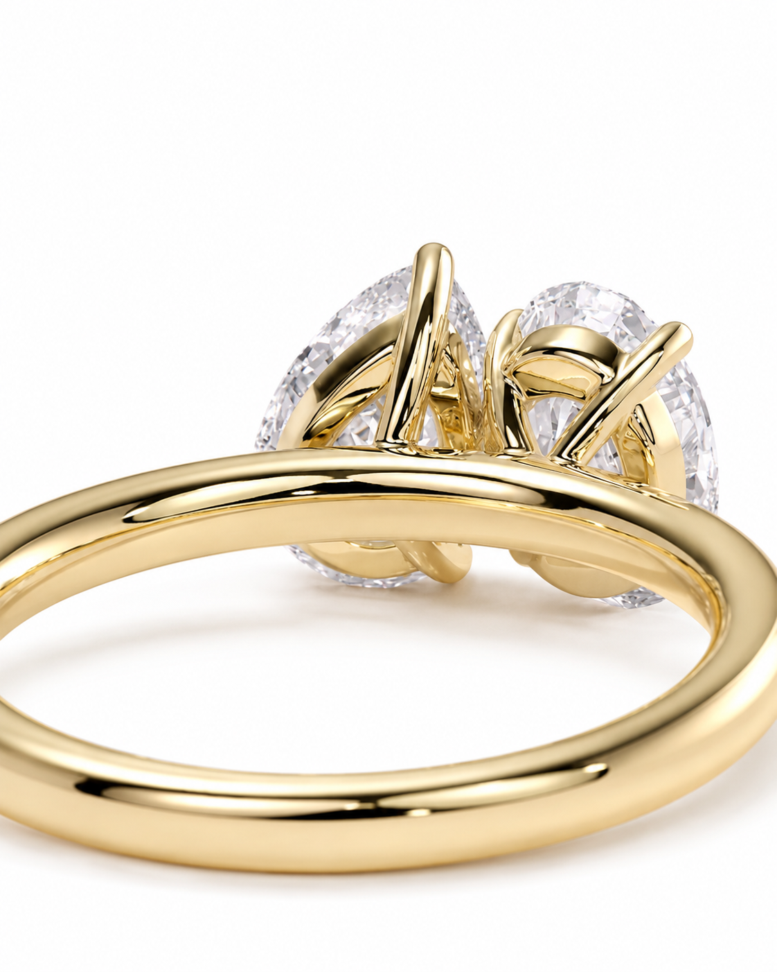 color_10K_YG, color_14K_YG &&A close-up shot of a yellow gold ring featuring a double pear-cut diamond setting on a clean white background.
