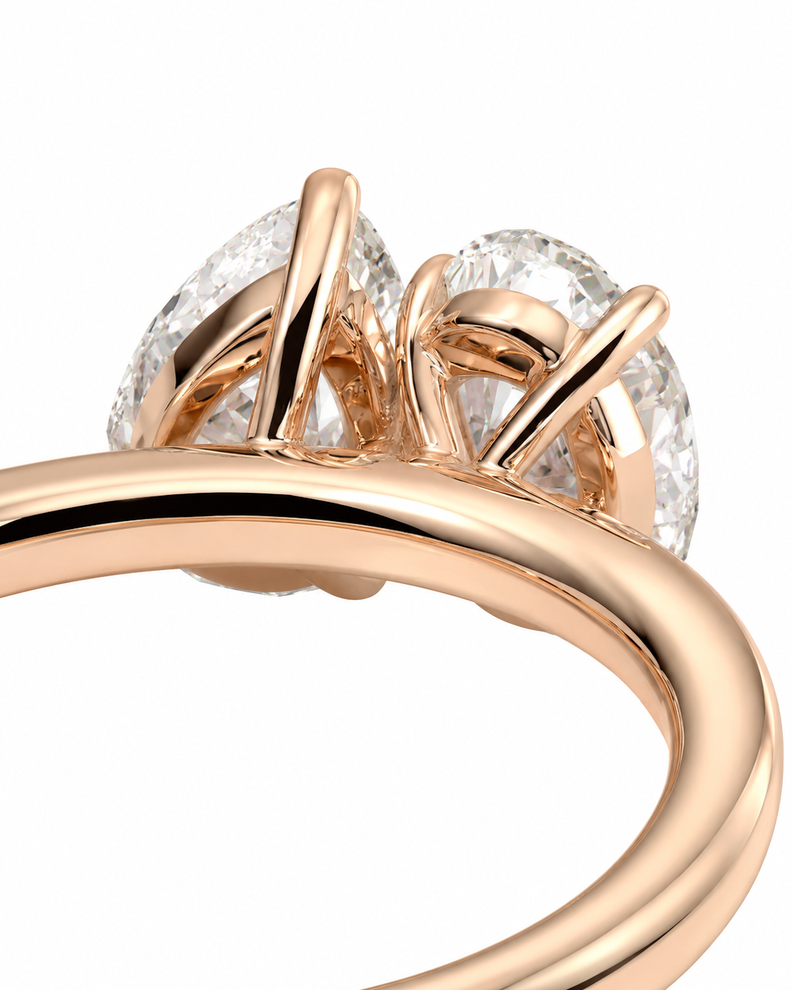 color_10K_RG, color_14K_RG &&Close-up of a rose gold ring with two pear-cut clear gemstones in a split setting, shown on a white background.