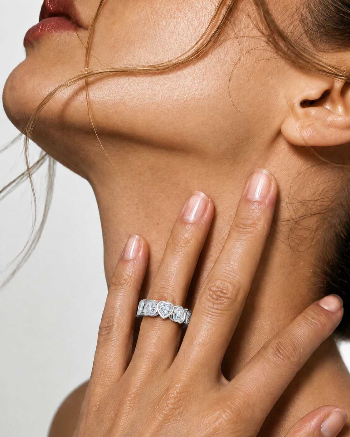 color_925_SIL,color_935_ARG,color_10K_WG, color_14K_WG &&	
A close-up lifestyle shot of a woman's hand resting on her neck, wearing a silver-toned diamond eternity ring.
