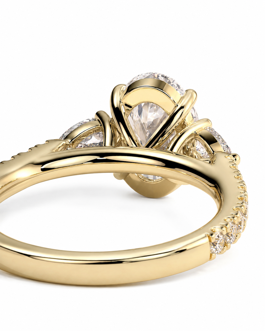 color_10K_YG, color_14K_YG &&A close-up of a yellow gold ring featuring a pear-cut center stone and smaller side stones, shown on a clean white background.