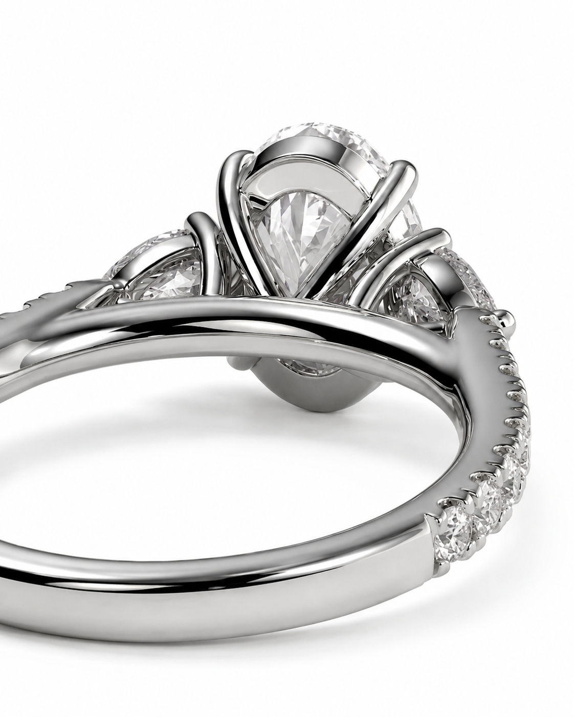 color_925_SIL,color_935_ARG,color_10K_WG, color_14K_WG &&A close-up studio shot of a silver-toned ring with a pear-cut center stone and small clear accent stones along the band, shown on a white background.