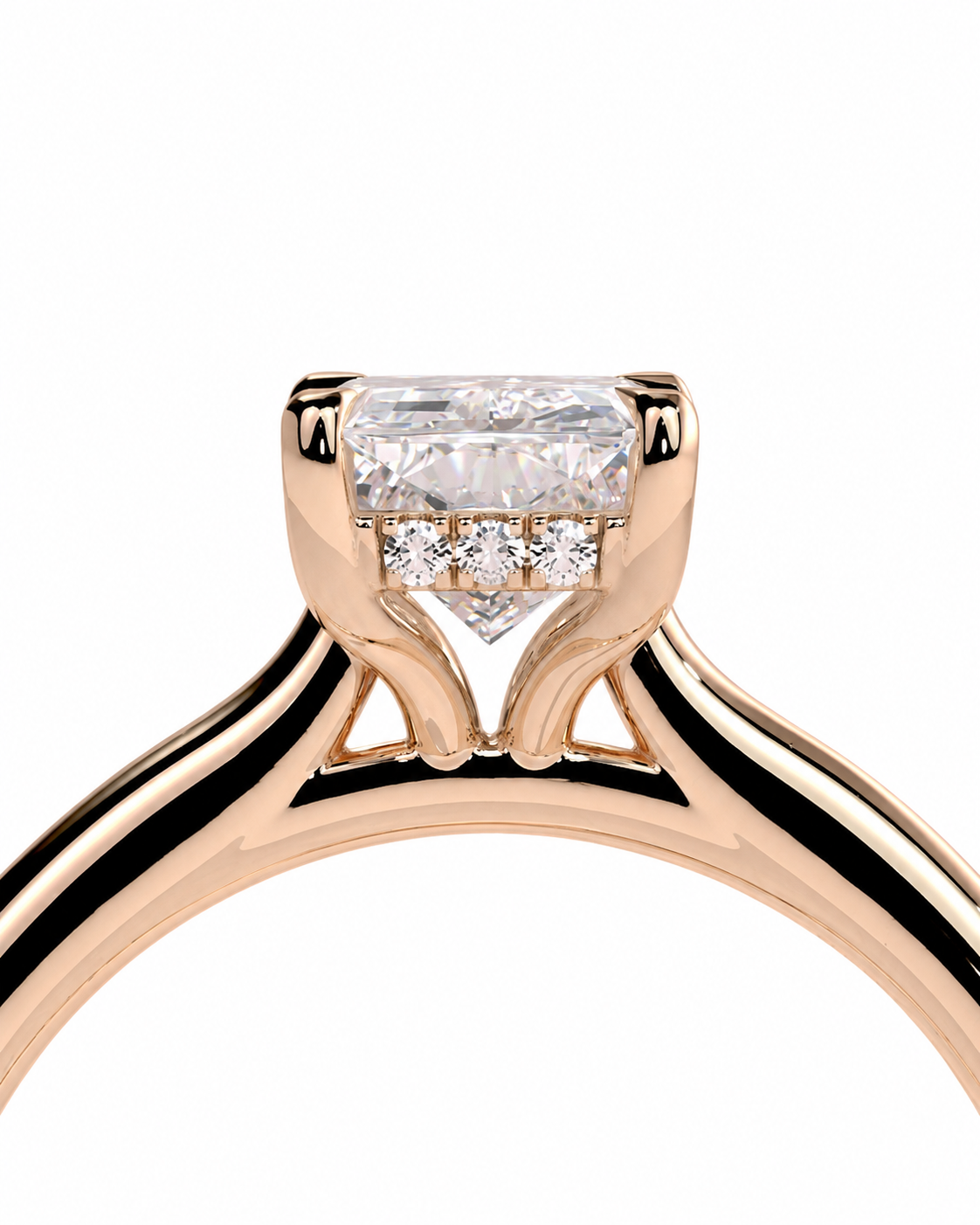 color_10K_RG, color_14K_RG &&Close-up of a rose gold engagement ring featuring a rectangular clear center stone with three small round stones in a row below it, set on a polished band against a white background.