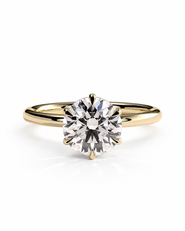 color_10K_YG, color_14K_YG &&A classic solitaire engagement ring featuring a round brilliant-cut diamond set in a yellow gold four-prong setting, on a polished yellow gold band, shot against a seamless white background.