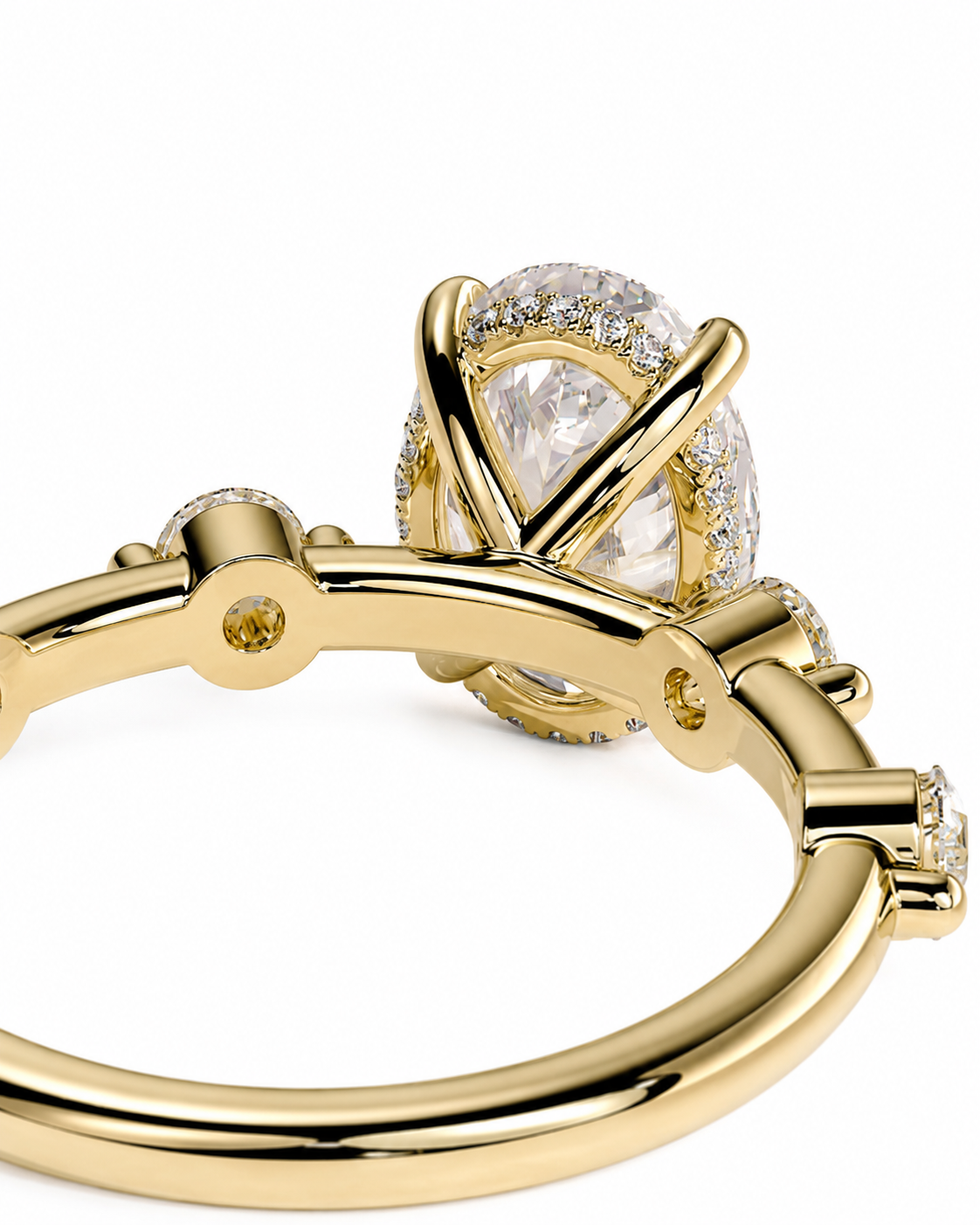 color_10K_YG, color_14K_YG &&A close-up of a gold ring featuring a large oval clear center stone surrounded by a halo of small clear stones, with additional small stones along the band, set against a plain white background.