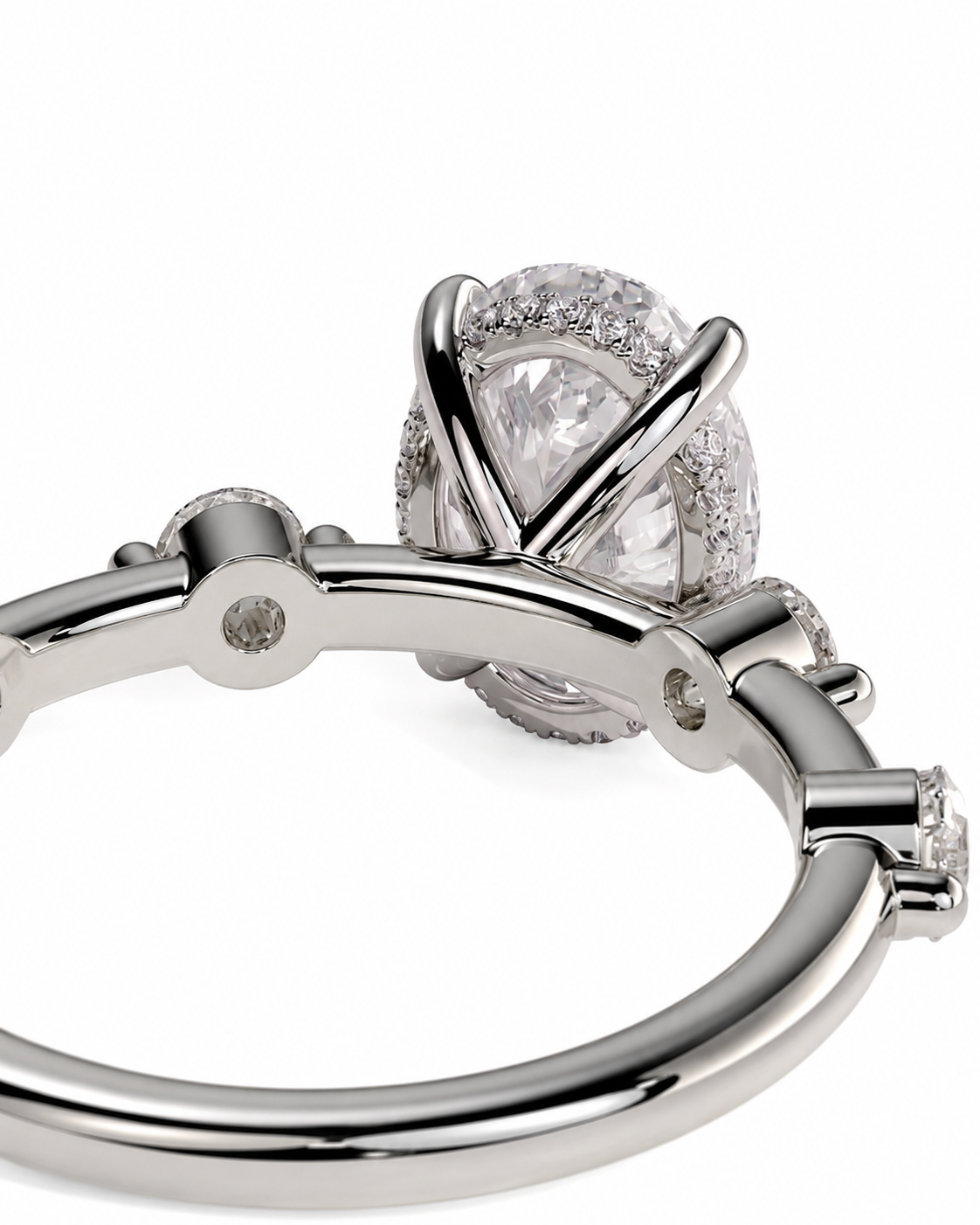 color_925_SIL,color_935_ARG,color_10K_WG, color_14K_WG &&A close-up studio shot of a silver-toned bangle ring with a large pear-cut clear center stone and a halo of small clear stones, set against a plain white background.