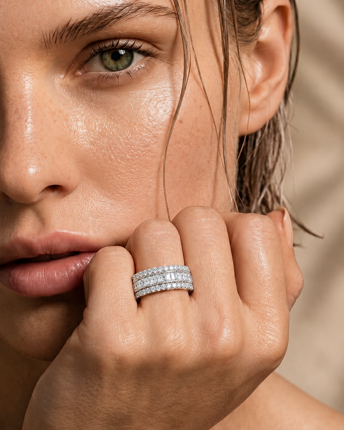 color_925_SIL,color_935_ARG,color_10K_WG, color_14K_WG &&	
A close-up lifestyle shot of a model wearing a double-row pave diamond band ring on her ring finger, with her hand resting near her chin against a soft beige background.