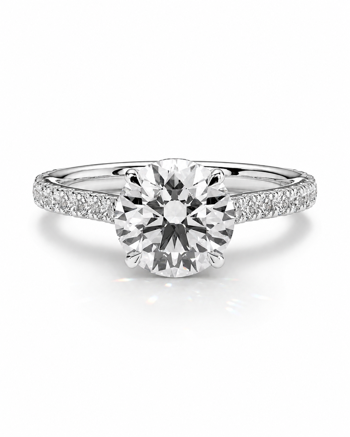 color_925_SIL,color_935_ARG,color_10K_WG, color_14K_WG &&A round-cut diamond engagement ring with a six-prong setting on a polished silver-colored band accented with pave diamonds, shown on a clean white background.