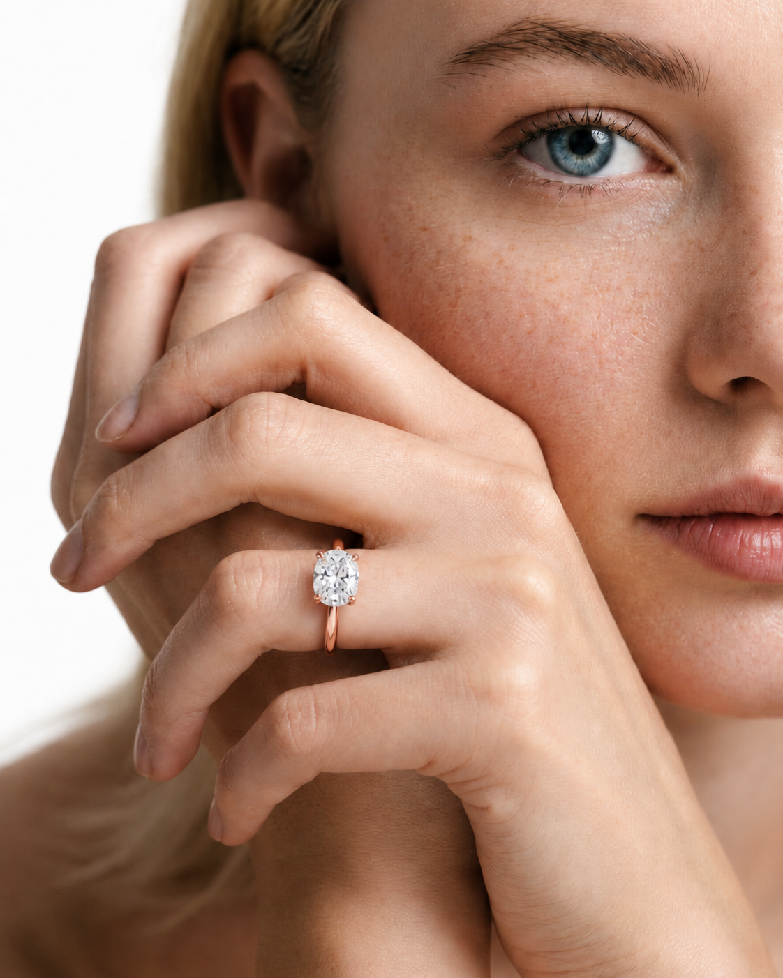 color_10K_RG, color_14K_RG &&A close-up lifestyle shot of a woman wearing a rose gold ring with a round-cut clear gemstone on her finger, set against a clean white background.