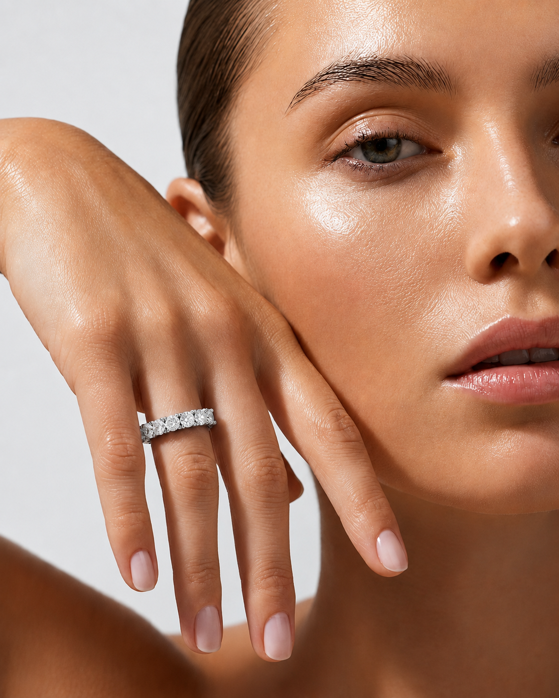 color_925_SIL,color_935_ARG,color_10K_WG, color_14K_WG &&	
A close-up lifestyle shot of a model wearing a silver diamond band ring on her finger, with her hand resting against her cheek against a light gray background.