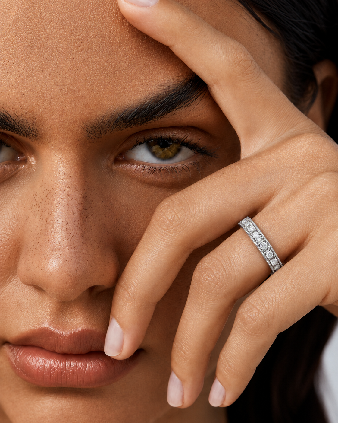 color_925_SIL,color_935_ARG,color_10K_WG, color_14K_WG &&	
A close-up lifestyle shot of a model wearing a silver band ring set with small clear stones on her ring finger.