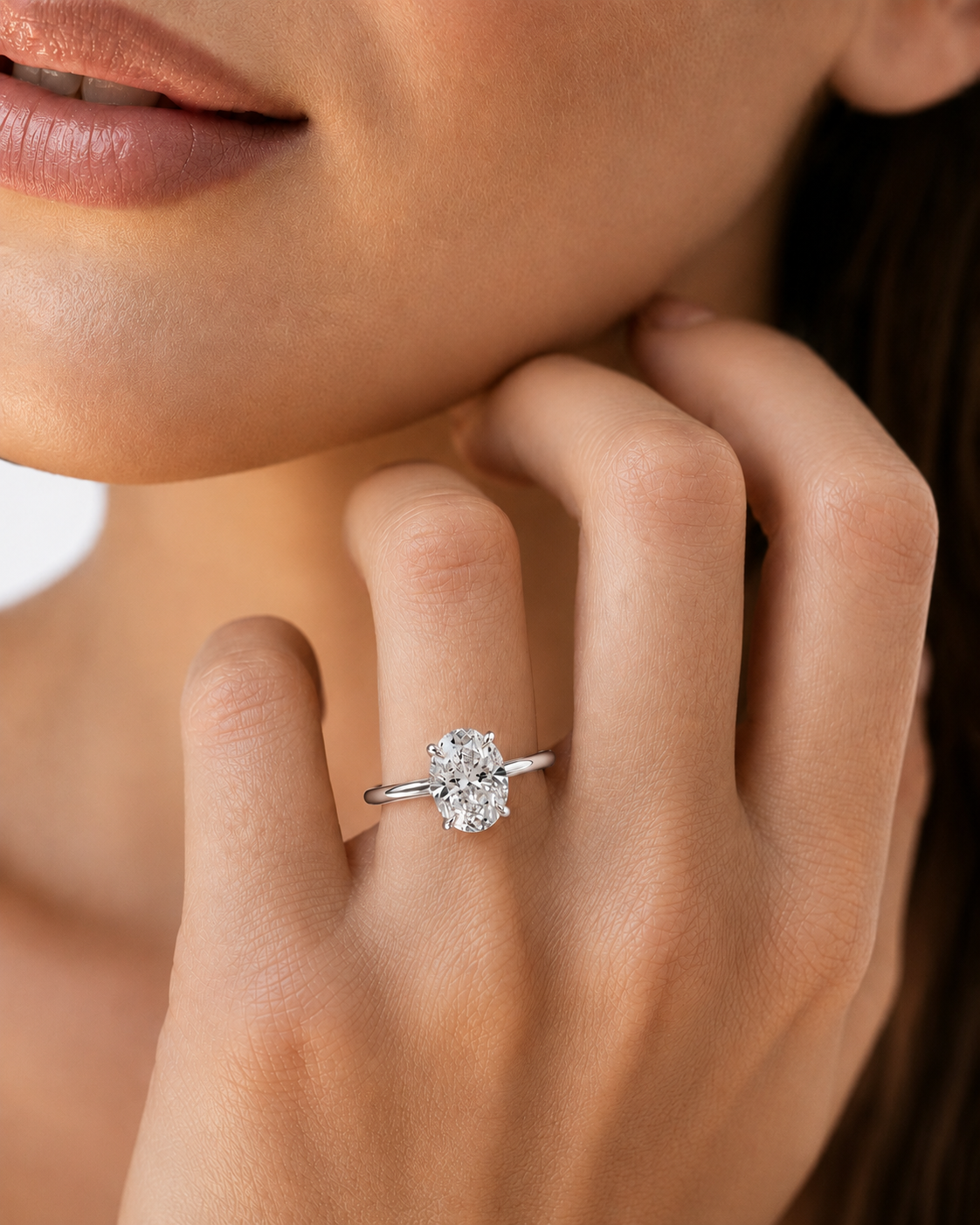 color_925_SIL,color_935_ARG,color_10K_WG, color_14K_WG &&A close-up lifestyle shot of a woman wearing a silver-toned diamond ring with a round-cut center stone on her finger.