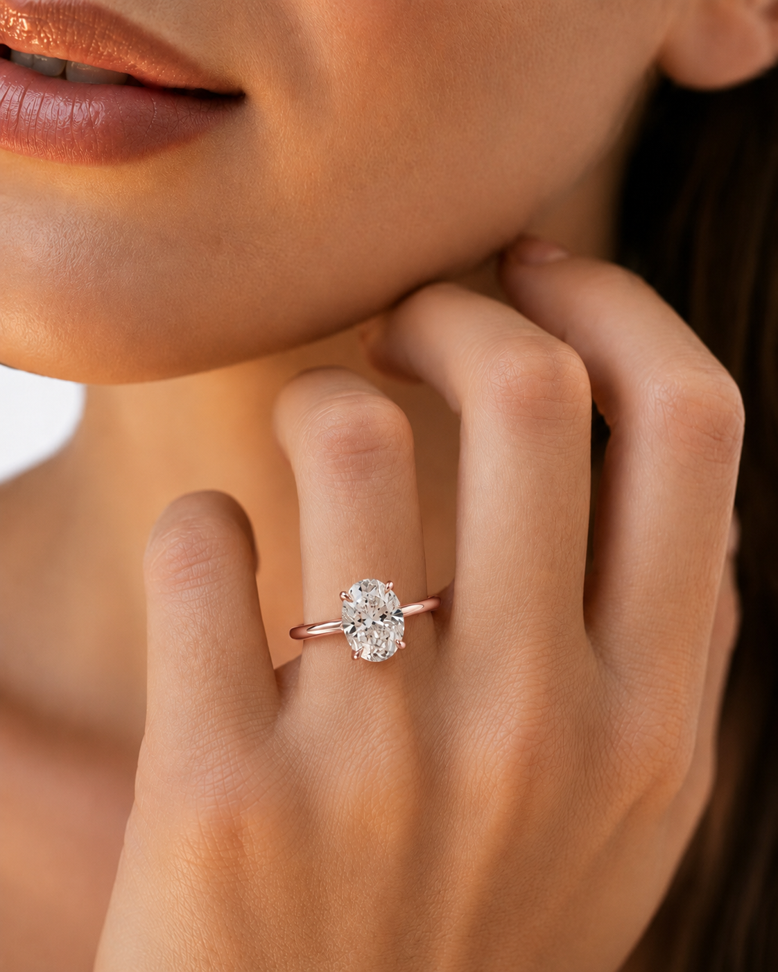 color_10K_RG, color_14K_RG &&A close-up lifestyle shot of a woman's hand wearing a delicate rose gold ring with a round brilliant-cut clear gemstone.