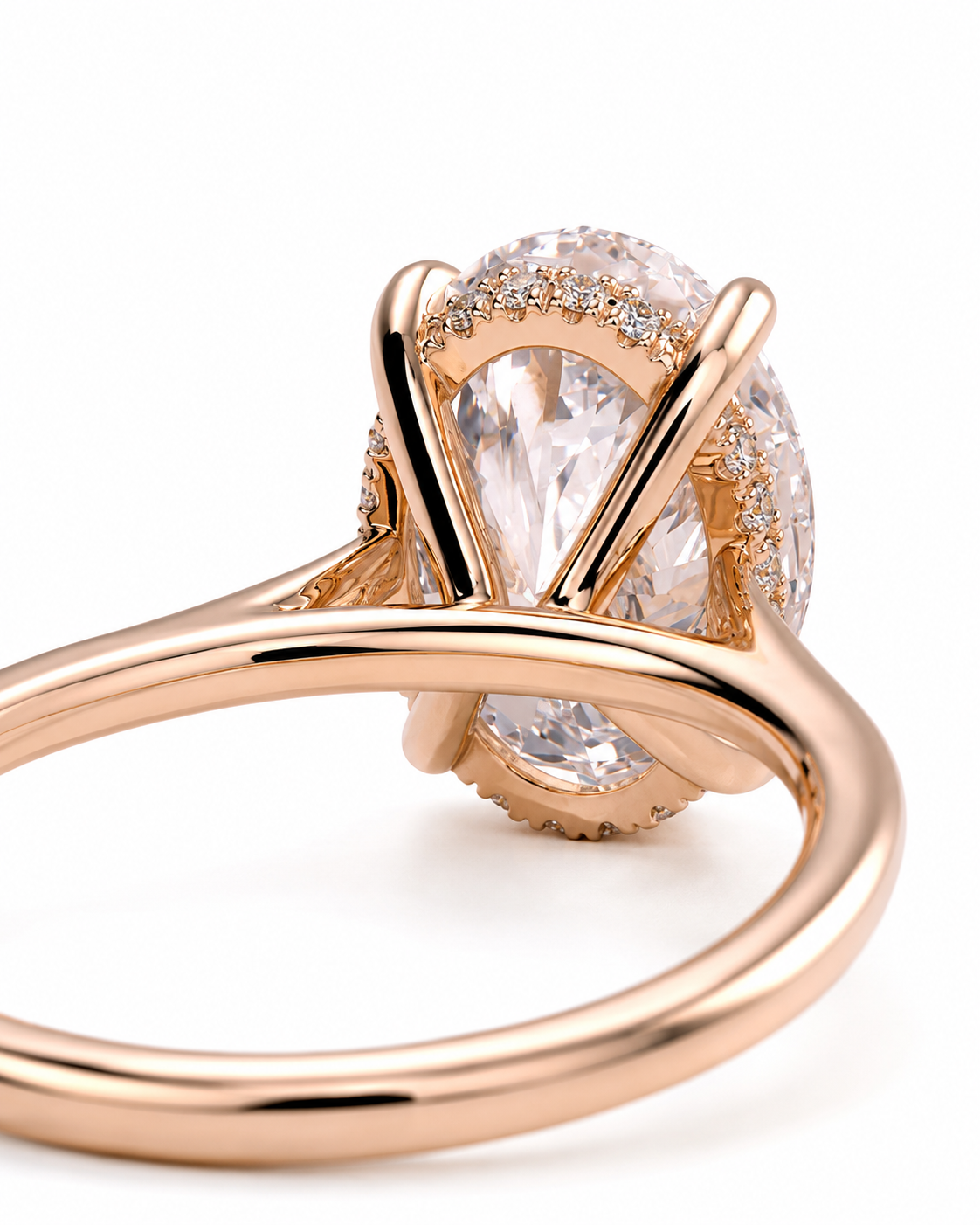 color_10K_RG, color_14K_RG &&Rose gold ring with a large oval clear center stone and a halo of small clear stones, photographed on a clean white background.