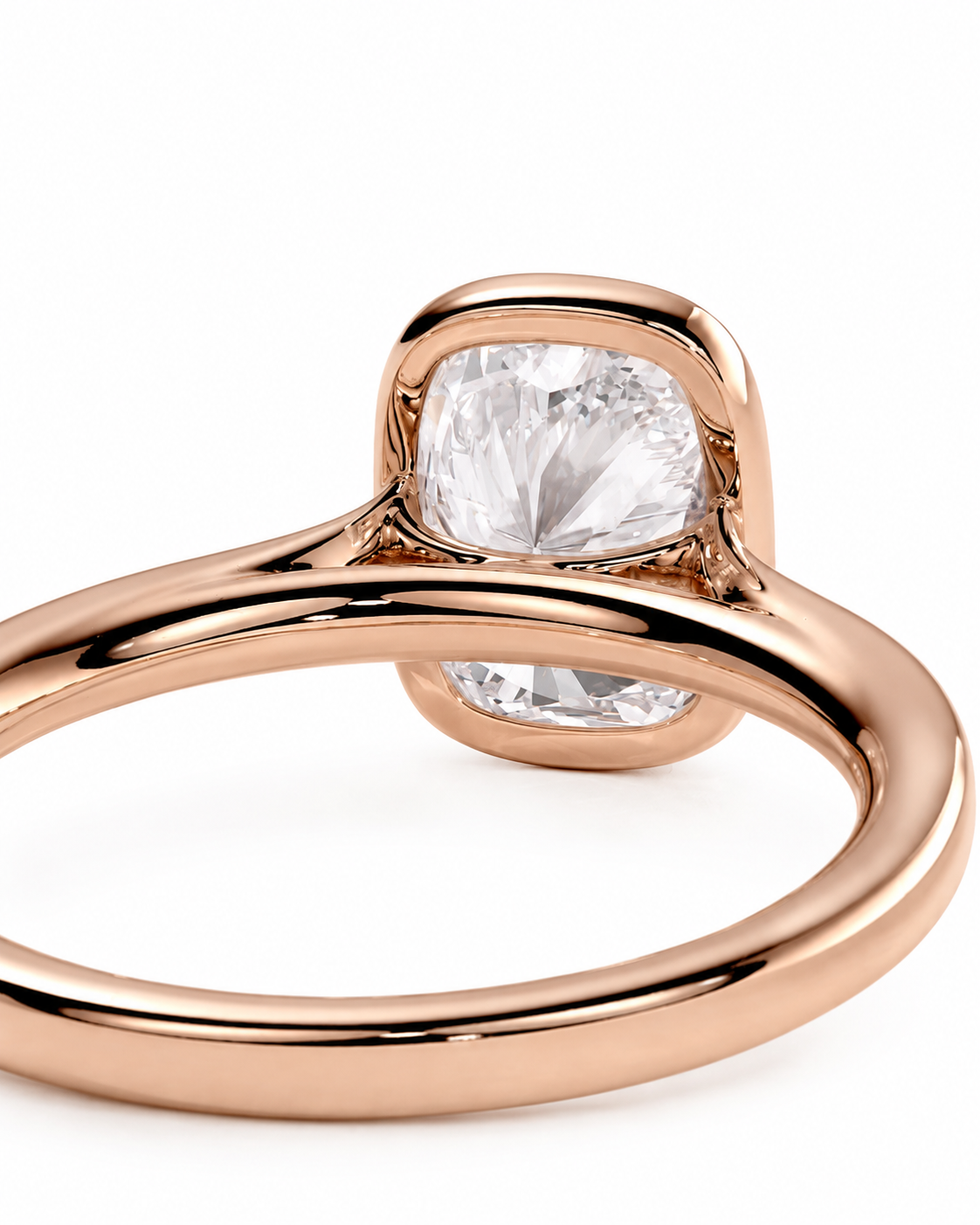 color_10K_RG, color_14K_RG &&A close-up of a rose gold ring featuring a cushion-cut clear gemstone in a bezel setting, shown on a clean white background.