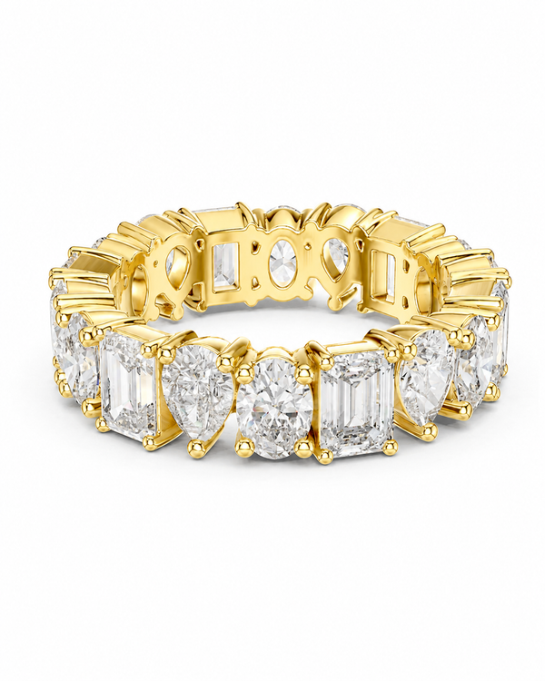color_10K_YG, color_14K_YG &&	
A yellow gold eternity ring featuring a continuous row of clear gemstones, including emerald, pear, and round-cut diamonds, set against a plain white background.