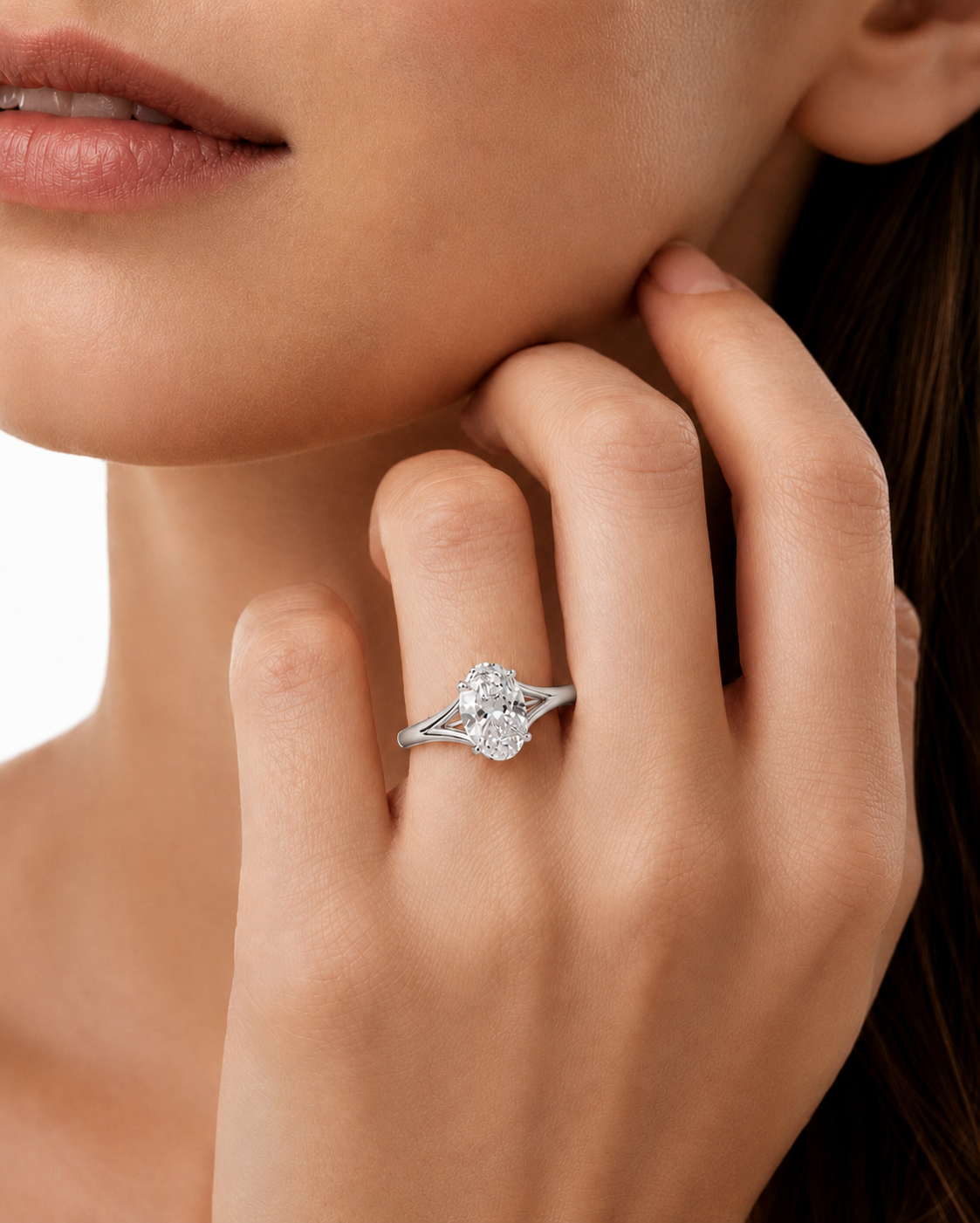 color_925_SIL,color_935_ARG,color_10K_WG, color_14K_WG &&A close-up lifestyle shot of a woman wearing a silver-toned diamond ring on her finger, with her hand resting near her chin against a clean white background.