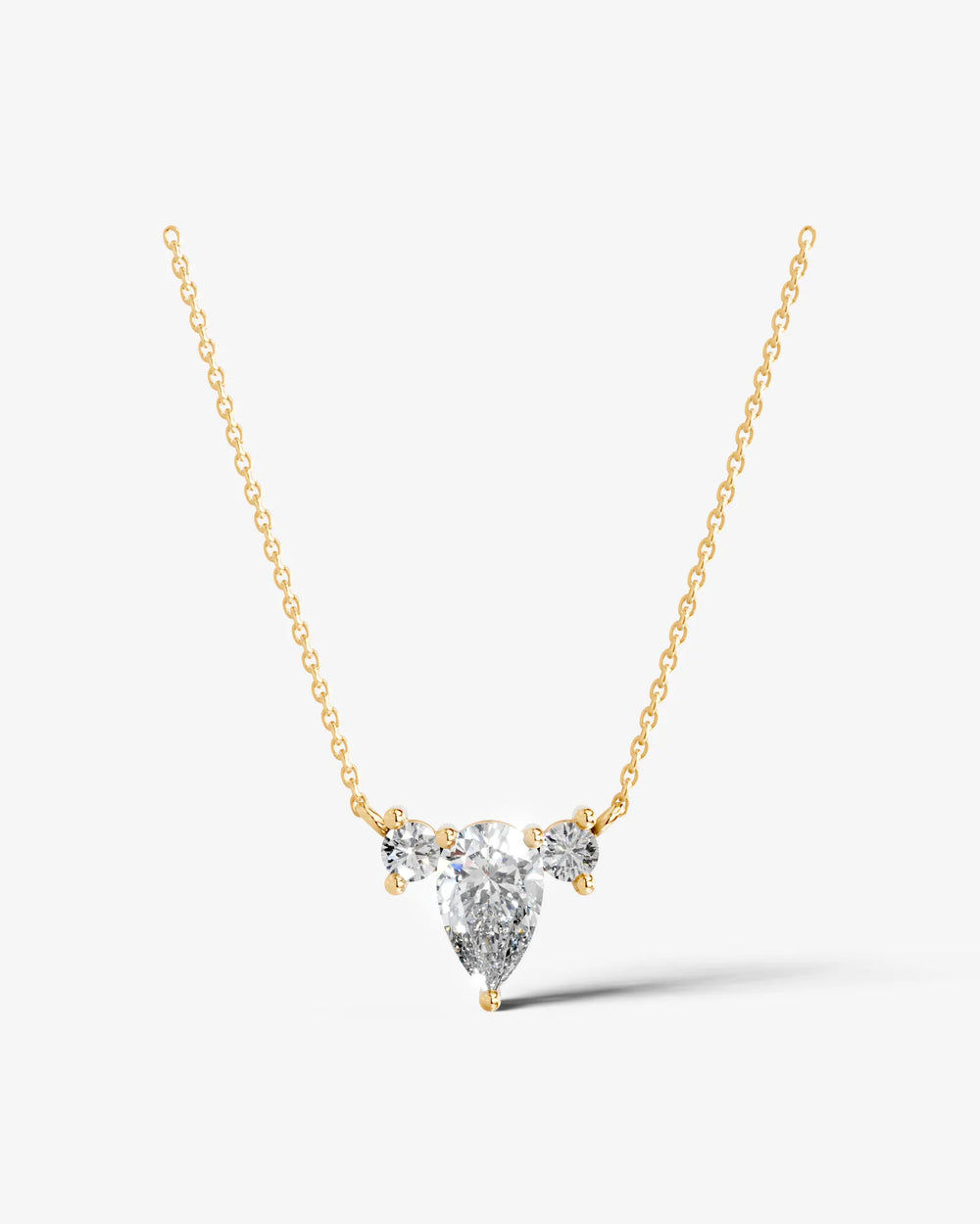 Side profile of a pear Moissanite pendant necklace showcasing the raised basket setting and elegant three-stone design.