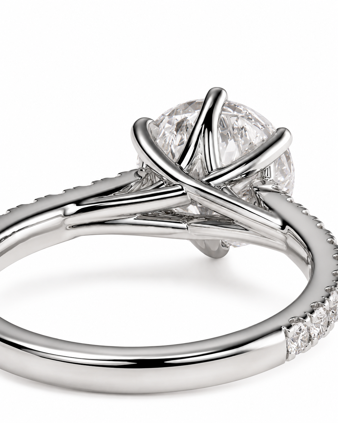color_925_SIL,color_935_ARG,color_10K_WG, color_14K_WG &&A close-up studio shot of a silver-toned engagement ring with a round clear gemstone in a prong setting and a split shank featuring small pave accents on a white background.