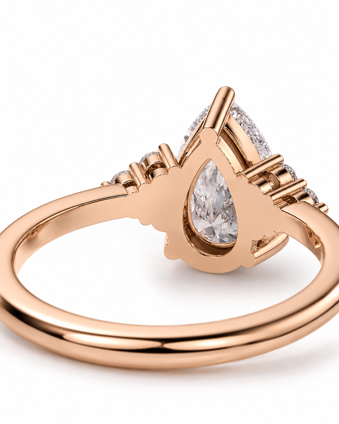 color_10K_RG, color_14K_RG &&Rose gold ring with a pear-cut clear center stone and small side stones, shown on a clean white background.