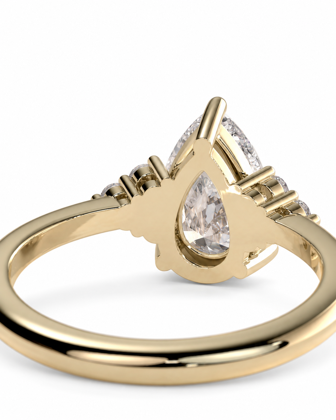color_10K_YG, color_14K_YG &&Close-up of a pear moissanite engagement ring with brilliant round side stones.
