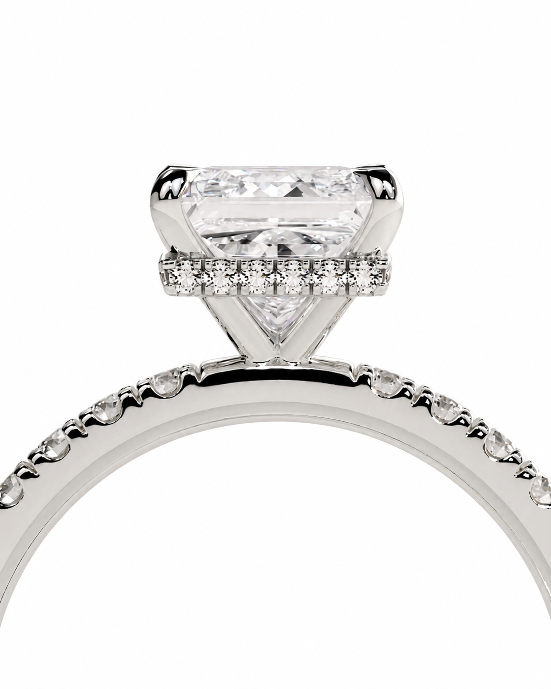 color_925_SIL,color_935_ARG,color_10K_WG, color_14K_WG &&A close-up studio shot of a silver-toned diamond ring featuring a large triangular solitaire center stone and a halo of small diamonds, with a pave-set band on a white background.