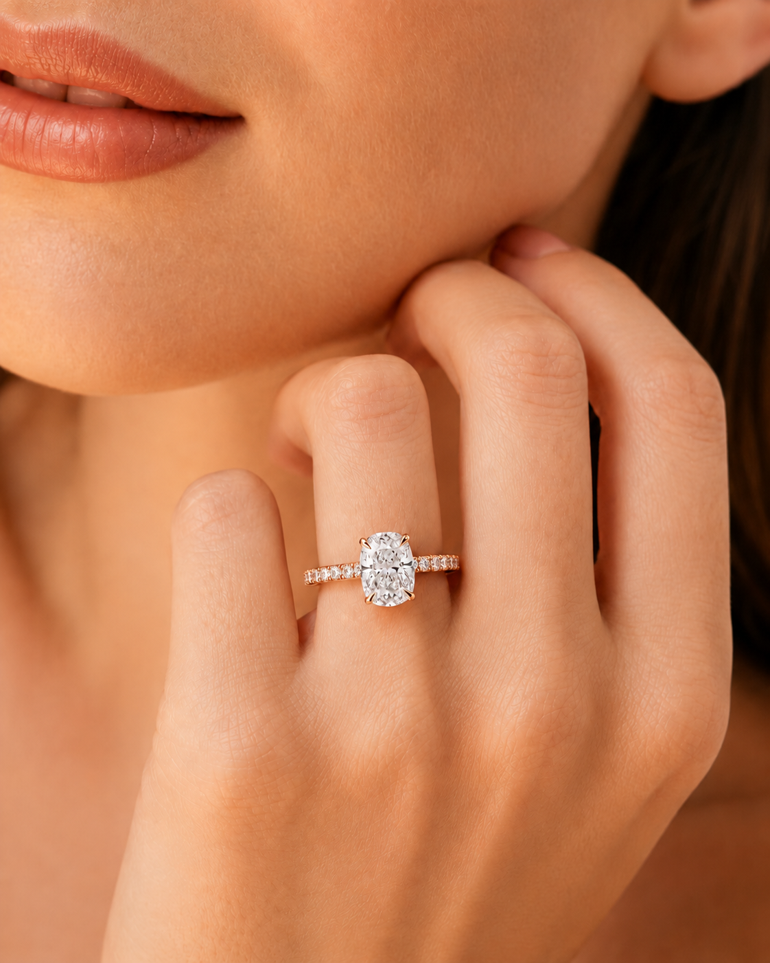 color_10K_RG, color_14K_RG &&A close-up lifestyle shot of a model wearing a diamond engagement ring. The ring features a round brilliant-cut center stone set on a thin, pave-set gold band.