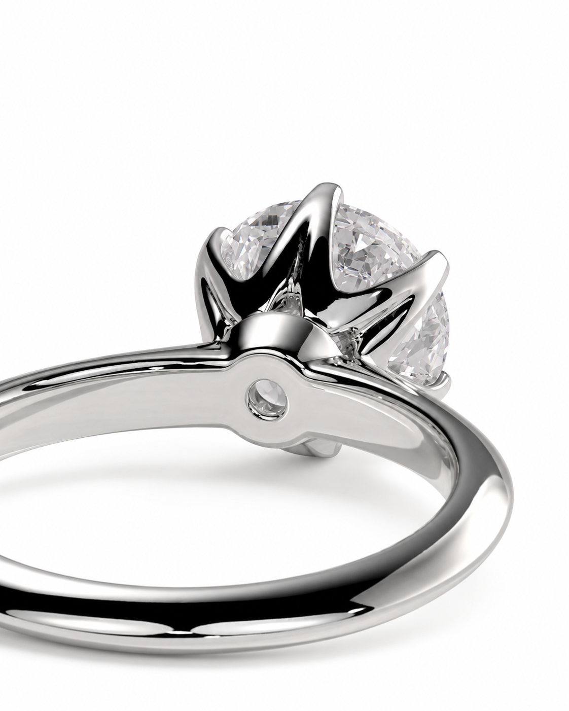 color_925_SIL,color_935_ARG,color_10K_WG, color_14K_WG &&A close-up studio shot of a silver-toned ring with a brilliant round-cut clear gemstone in a crown-like prong setting, shown on a white background.