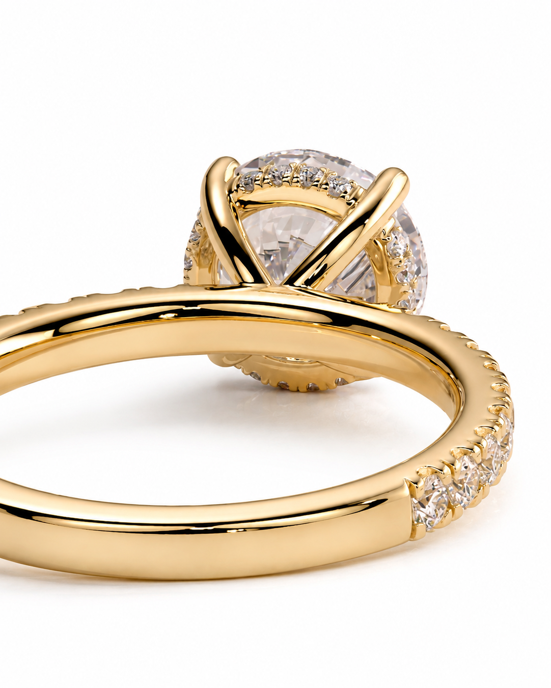 color_10K_YG, color_14K_YG &&A close-up studio shot of a gold ring with a large clear round center stone and a halo of small clear stones, set against a clean white background.