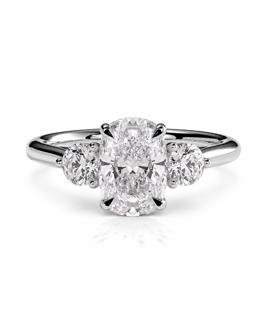 color_925_SIL,color_935_ARG,color_10K_WG, color_14K_WG &&A three-stone diamond ring featuring a central oval-cut diamond flanked by two round-cut diamonds on a polished silver-colored band, set against a clean white background.