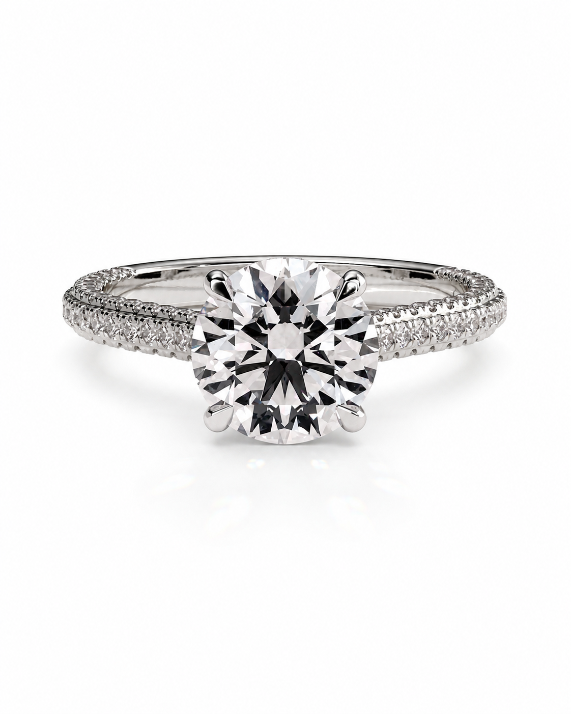 color_925_SIL,color_935_ARG,color_10K_WG, color_14K_WG &&A classic solitaire engagement ring featuring a round brilliant-cut center stone in a four-prong setting on a polished silver-colored band accented with pave side stones, shown on a clean white background.