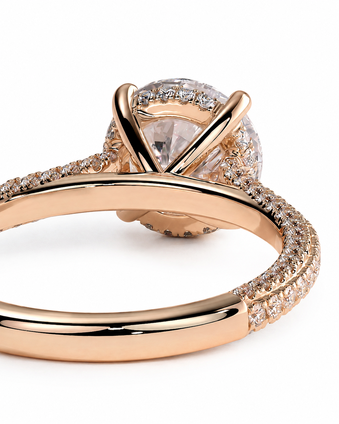 color_10K_RG, color_14K_RG &&A close-up of a rose gold engagement ring featuring a large pear-cut center stone surrounded by a halo of small clear stones, with a split shank band also accented with pave stones, set against a plain white background.