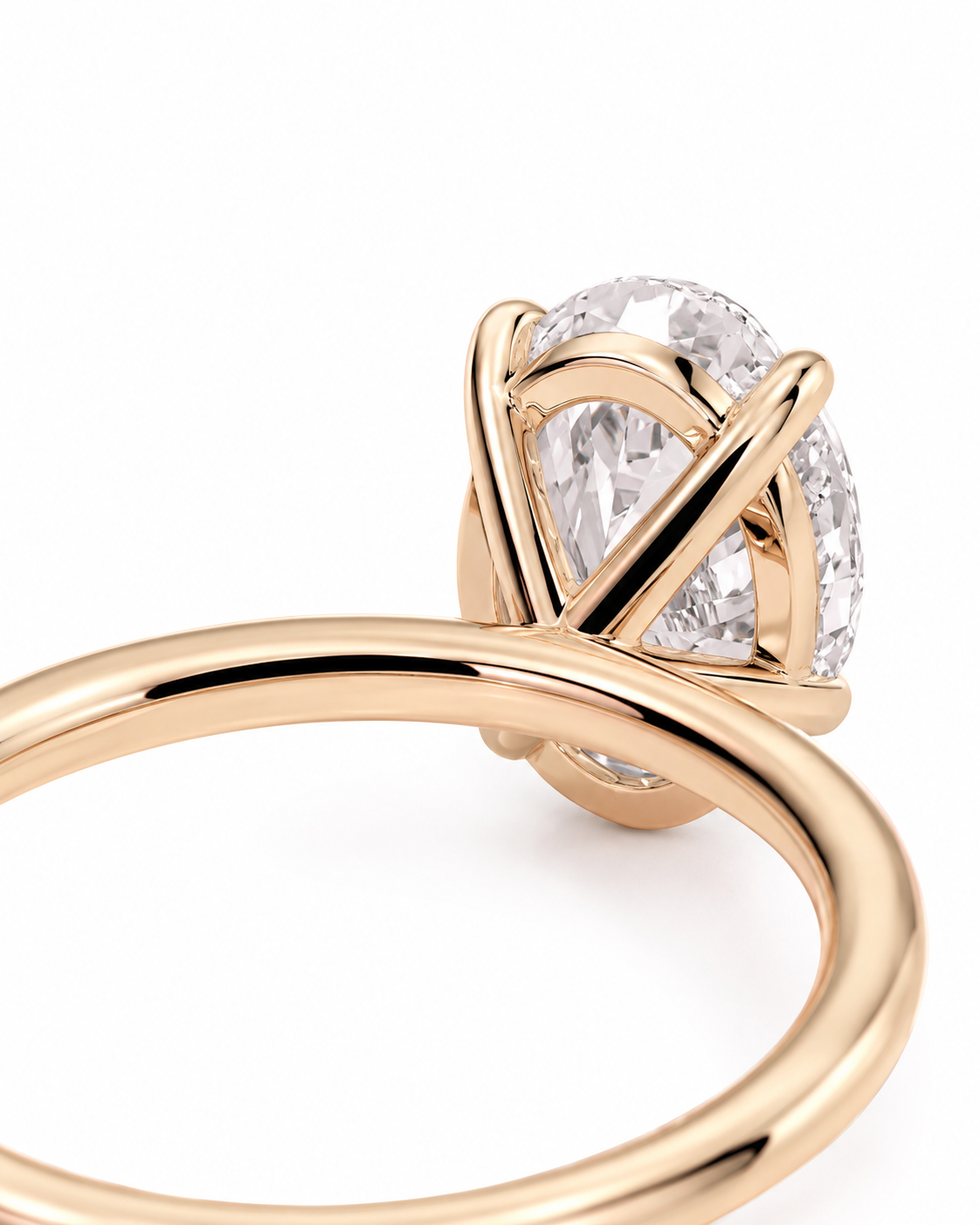 color_10K_RG, color_14K_RG &&A close-up shot of a rose gold ring featuring a large oval-cut clear gemstone in a wrap-style setting, shown against a clean white background.