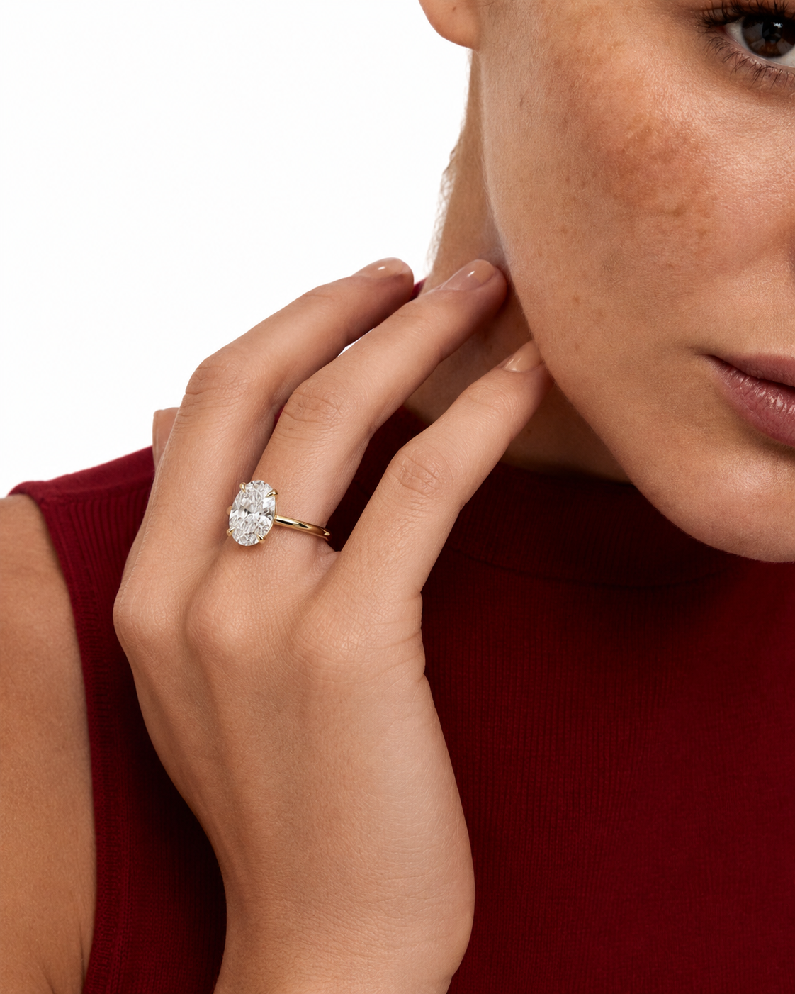 color_10K_YG, color_14K_YG &&A close-up lifestyle shot of a model wearing a gold ring with a large oval-cut clear gemstone on her finger, set against a clean white background.