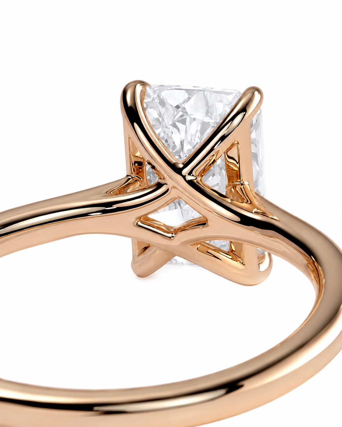 color_10K_RG, color_14K_RG &&A close-up of a rose gold ring featuring a large rectangular clear gemstone in a four-prong setting with an interlocking crisscross design on the band, set against a plain white background.