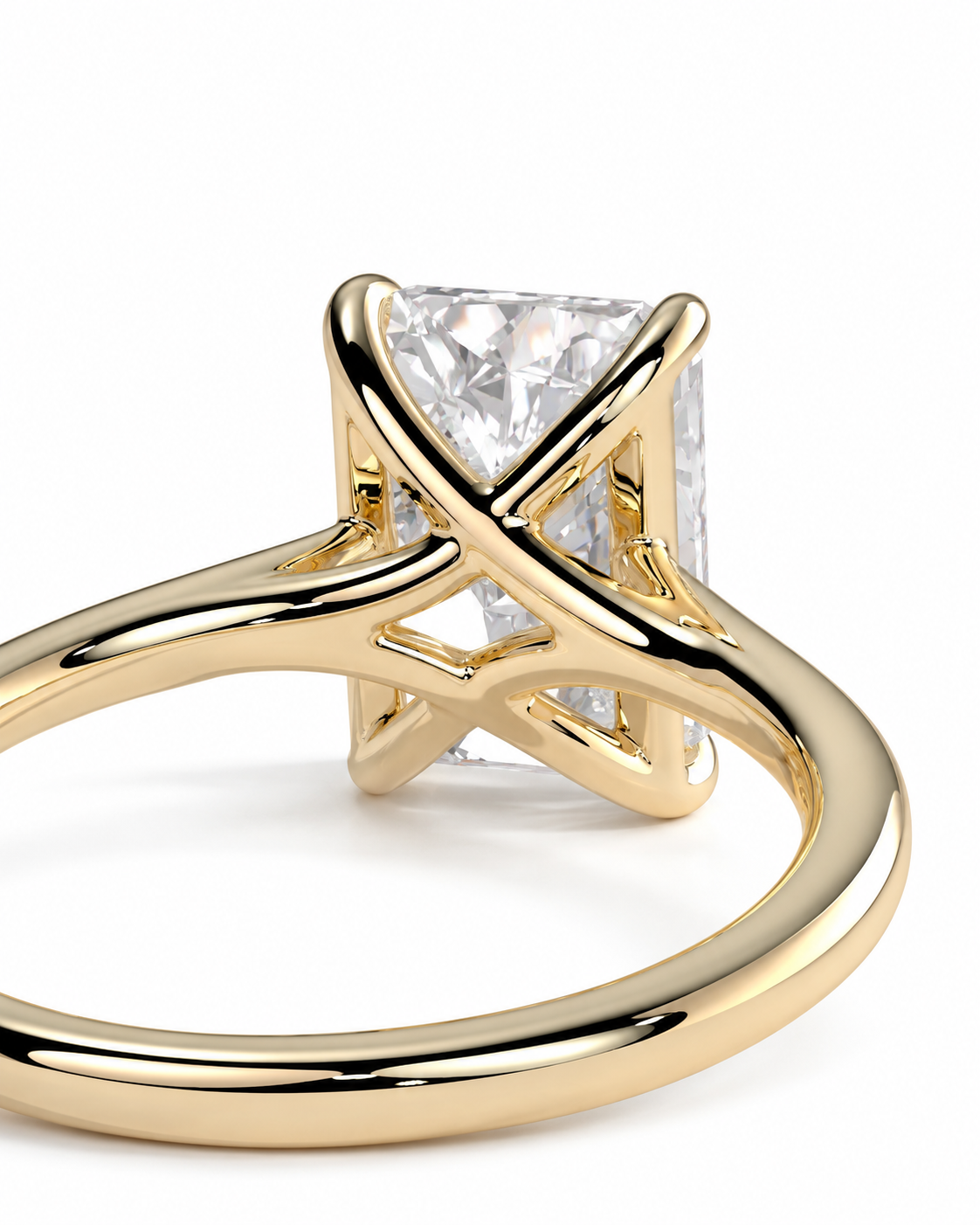 color_10K_YG, color_14K_YG &&A close-up of a yellow gold ring featuring an open, crisscrossed band design and a rectangular clear gemstone in a prong setting, shown against a plain white background.