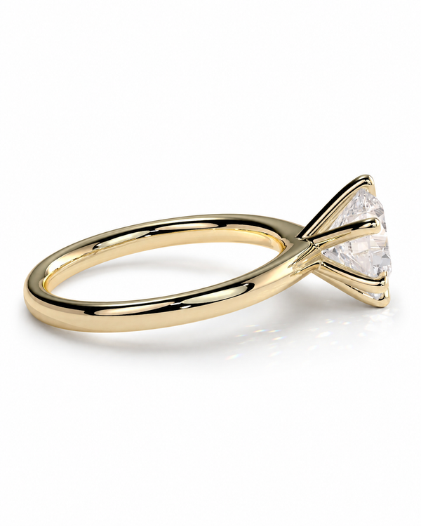 color_10K_YG, color_14K_YG &&A yellow gold solitaire engagement ring with a triangular bezel setting holding a clear round-cut gemstone, shown on a clean white background.