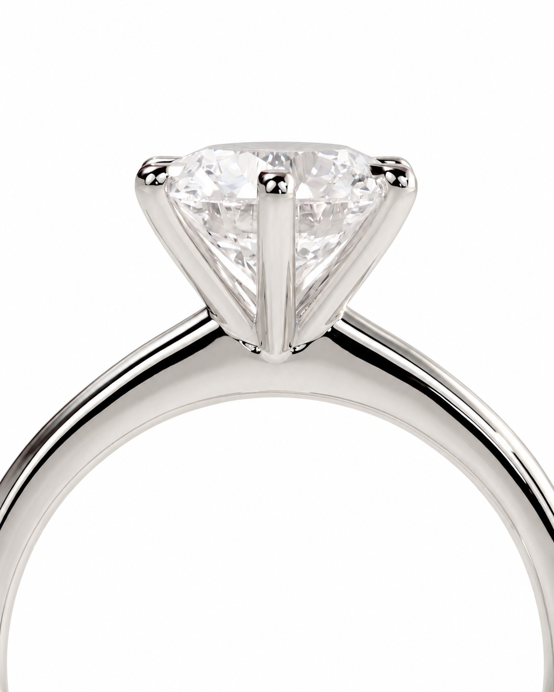 color_925_SIL,color_935_ARG,color_10K_WG, color_14K_WG &&A close-up studio shot of a solitaire engagement ring featuring a triangular-cut clear gemstone in a polished silver-colored metal setting, shown against a plain white background.