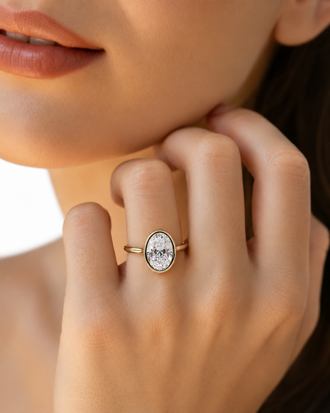 color_10K_YG, color_14K_YG &&A close-up lifestyle shot of a model's hand wearing a delicate gold ring with an oval, textured white stone.