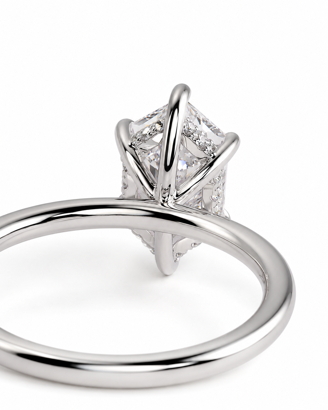 color_925_SIL,color_935_ARG,color_10K_WG, color_14K_WG &&A close-up studio shot of a silver-toned ring featuring a large rectangular clear gemstone in a prong setting with smaller accent stones along the band, shown against a plain white background.