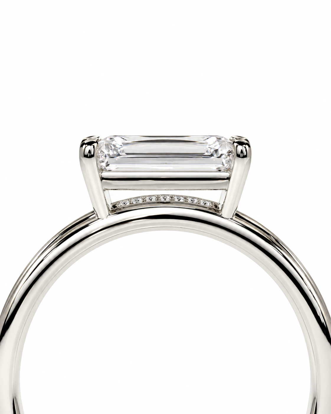 color_925_SIL,color_935_ARG,color_10K_WG, color_14K_WG &&A close-up studio shot of a silver engagement ring featuring a rectangular baguette-cut clear gemstone in a four-prong setting, with a row of small accent diamonds along the band, set against a plain white background.